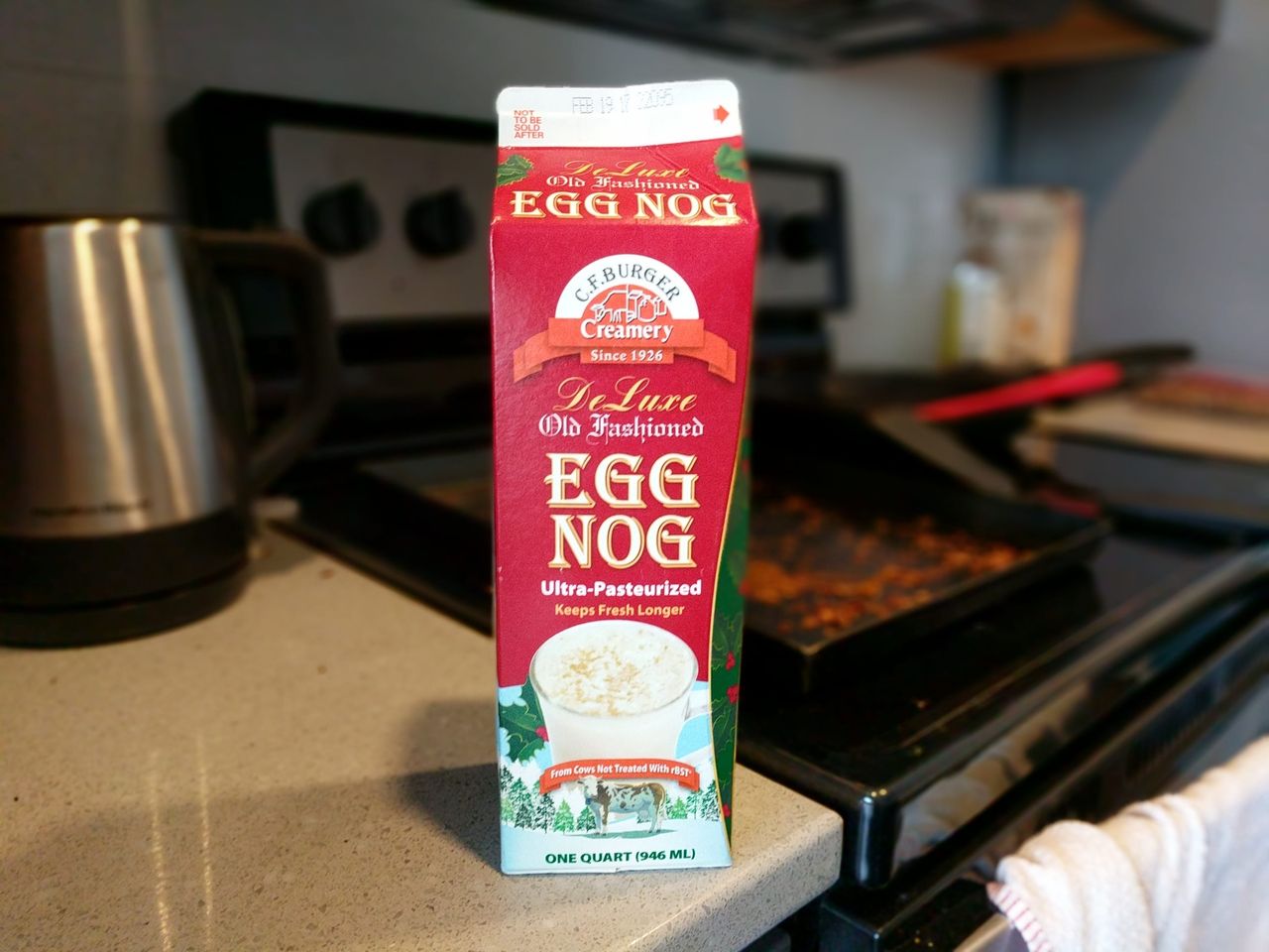 A carton of C.F. Burger Creamery De Luxe Old Fashioned Egg Nog on a stovetop